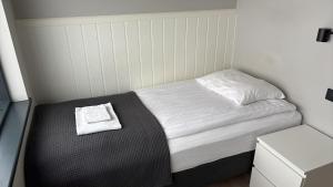 a small bed in a small room with a stool at Landbrot Guesthouse in Kirkjubæjarklaustur