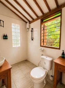 a bathroom with a toilet and a sink and a window at 5BR, Ocean View, Private Pool, Villas Roc-Azur in Sampalan +50 photos