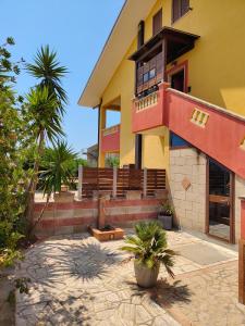 a house with stairs and a building with palm trees at La Terrazza in Carrao
