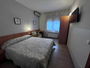 a hotel room with a bed and a television at Rosaleda Self-Hotel in Fondarella