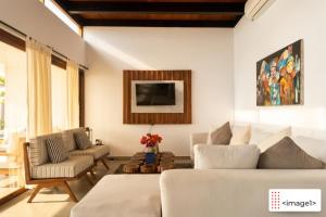 a living room with a white couch and chairs at Jama Campay Hotel by Otium in Los Camarones