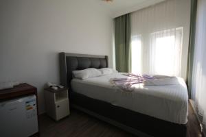 a bedroom with a large bed with a window at Okan Ali Gürsoy Otel in Ayvalık +2 photos