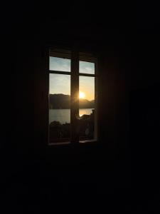 a window with a view of the sunset at Olcium Holiday Rooms in Mandello del Lario +40 photos