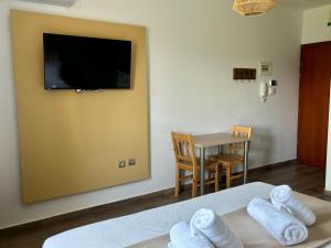 a room with a tv on the wall and a table at Boho House Florina in Florina