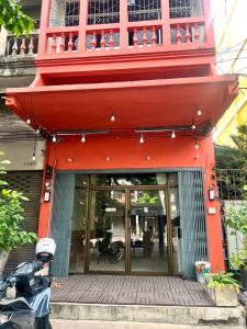 a red building with a balcony on top of it at arakhouse อารักษ์เฮ้าส์ in Godown