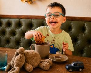 a young boy eating food at a table with a teddy bear at Hotel Central Nürnberg Hauptbahnhof in Nuremberg +46 photos