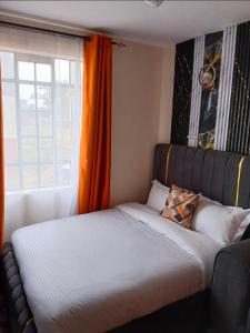 a bed sitting in a room with a window at Haven Nest in Machakos