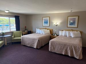 a hotel room with two beds and a chair at Bayview Inn in Crescent City