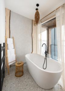 a white bath tub in a room with a window at Характер парк in Hatne