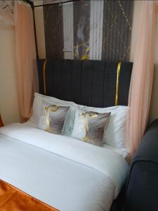 a bed with a black head board with pillows at Haven Nest in Machakos