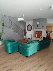 a living room with two green couches and a staircase at Casa do Azibo in Santa Combinha