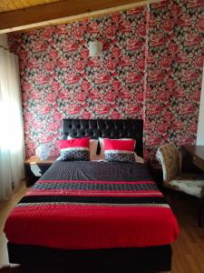 a bedroom with a large bed with a red blanket at Casa do Azibo in Santa Combinha