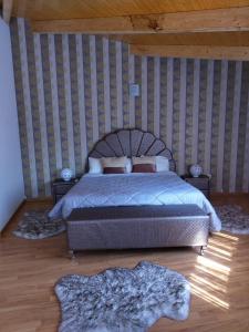 a bedroom with a bed and a striped wall at Casa do Azibo in Santa Combinha