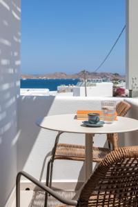 a table and chairs on a balcony with a view of the ocean at Clementina Hill in Naousa