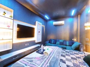 a bedroom with a bed and a couch and a tv at ML HOMESTAYS - For Family, Students, Parents, Couples in Phagwāra