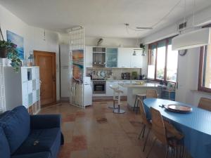 eine Küche und ein Wohnzimmer mit einer blauen Couch und einem Tisch in der Unterkunft Fronte Mare in Quercianella + 16 Fotos
