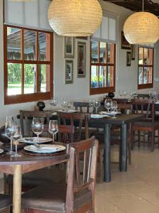 a dining room with wooden tables and chairs with wine glasses at Hotel Rede Beach in Trairi