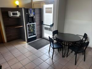 a dining room with a table and chairs and a refrigerator at Rosaleda Self-Hotel in Fondarella