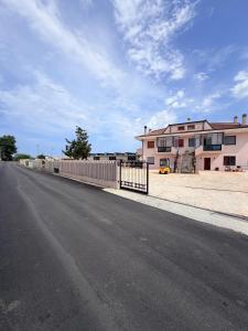 eine leere Straße neben einem Haus mit einem Zaun in der Unterkunft Cascina del colle - Casa Briè in Villamagna