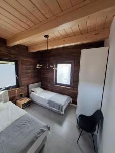 ein Schlafzimmer mit zwei Betten und einem Stuhl in der Unterkunft Bez Planu in Zambski Stare