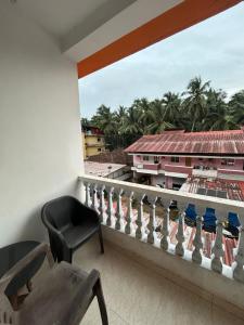 a balcony with a chair and a view of a building at Cassa ff guesthouse in Palolem +60 photos