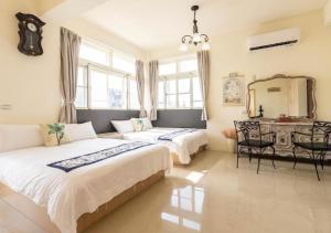 a bedroom with two beds and a table and a mirror at 奇凡小花園 獨棟包棟民宿推薦 適合親友多人聚會朋友小包棟一一近梅花湖羅東夜市 in Yilan City