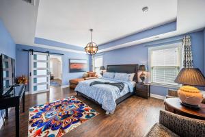 a bedroom with blue walls and a bed and a couch at The Blue Crown Manor at Concord Estates in Concord