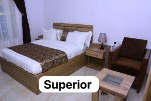 a hotel room with a bed and a chair at Bgl suites in Barakin Akawo