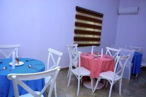 a dining room with tables and chairs and a window at Bgl suites in Barakin Akawo