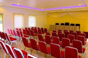 a conference room with red chairs and a podium at Bgl suites in Barakin Akawo