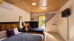 a bedroom with two beds and a television in it at Roxys Inn in Boca Chica