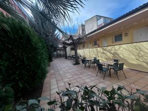 a patio with tables and chairs next to a building at Rosaleda Self-Hotel in Fondarella