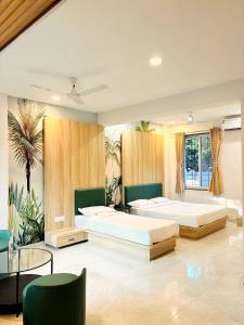 a bedroom with two beds and a glass table at Sukhawan Hotel in Kalamb