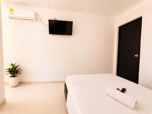 a bedroom with a bed and a tv on the wall at Renta Mar in Barranquilla