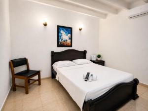 a bedroom with a large bed and a chair at Renta Mar in Barranquilla