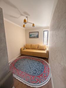 a living room with a couch and a rug at Alfaresortappartmens in Koshkolʼ