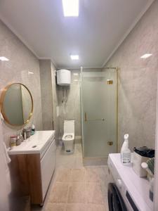a bathroom with a shower and a sink and a toilet at Alfaresortappartmens in Koshkolʼ