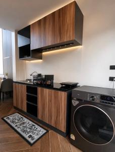 a kitchen with a washing machine in a kitchen at The Courtyard Heritage Pool Villa Udonthani in Udon Thani