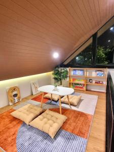 a living room with a table and a rug at The Courtyard Heritage Pool Villa Udonthani in Udon Thani