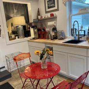a kitchen with a table with a vase of flowers on it at Scenic Vista Inn in North Conway +13 photos