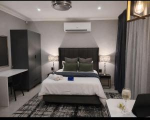 a bedroom with a large bed and a desk at F'leur Guesthouse in Mokopane