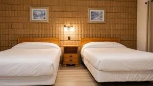 two beds in a small room with at Top Notch Motel in Wiarton