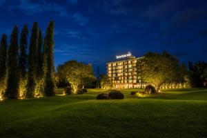 a hotel at night with a lawn and trees at The Par Phuket Hotel in Kathu