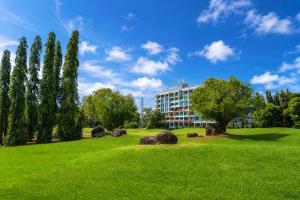a park with trees and a building in the background at The Par Phuket Hotel in Kathu +94 photos