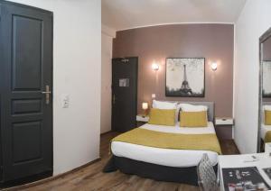 a hotel room with a large bed with yellow pillows at Hôtel Du Palais Bastia Centre in Bastia +8 photos