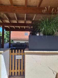 a wooden bench under a wooden roof with plants at Ferienwohnung Johanns Hof in Fürth