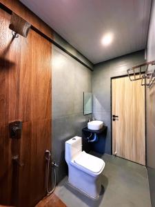 a bathroom with a toilet and a sink at Sukhawan Hotel in Kalamb