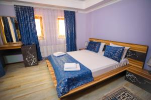 a bedroom with a large bed with blue pillows at Sheki Villa boutique in Sheki