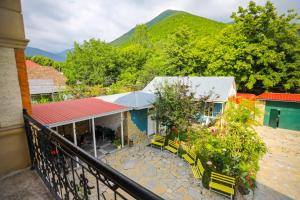 a balcony of a building with yellow chairs and trees at Sheki Villa boutique in Sheki