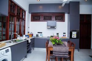 a kitchen with a sink and a table with flowers on it at Kasitha Ocean View Villa - Matara Beach Road in Matara